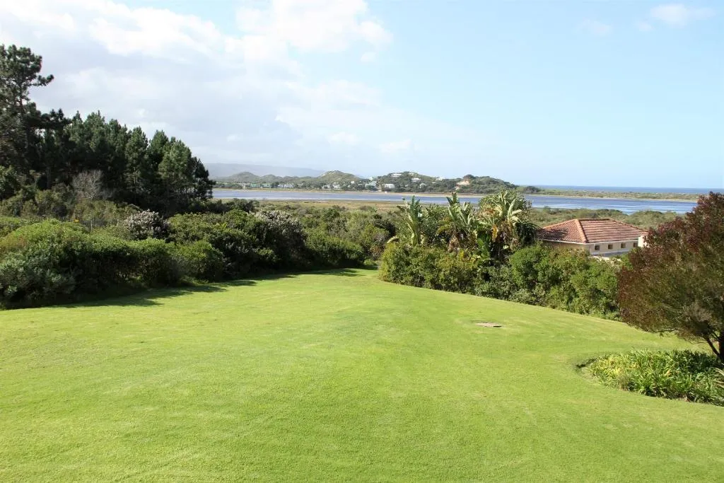 Manicured lawn framed by fynbos with the lagoon and hills in the distance