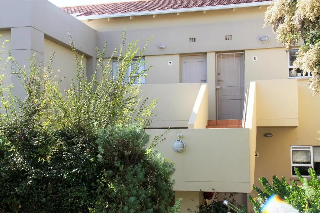 Exterior walkway and front doors of the ground-floor units within the estate