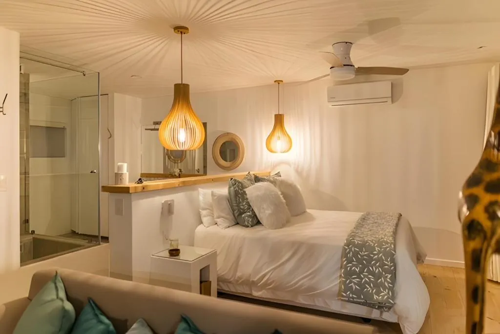 Bedroom with pendant lighting, ceiling fan, and an open en-suite bath and shower