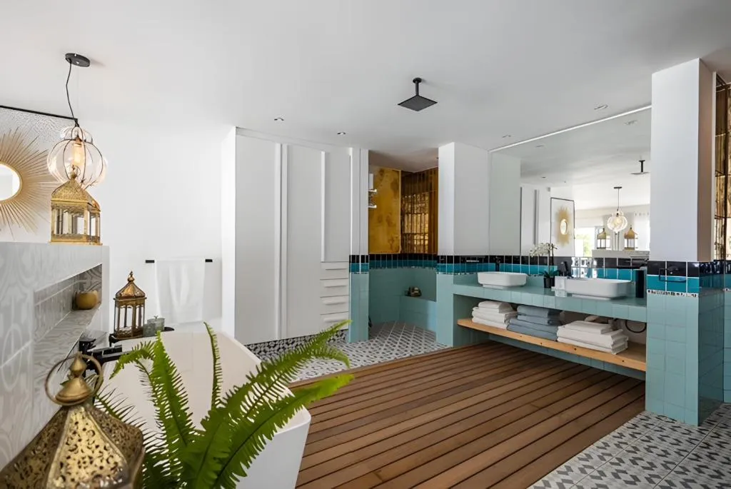 Teal-tiled bathroom with a freestanding tub, double vanity, and walk-through shower
