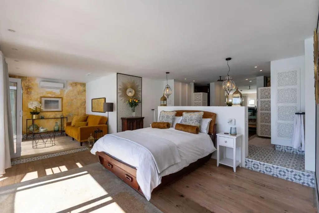 Second angle of the bedroom showing the open-plan lounge and mustard sofa beyond