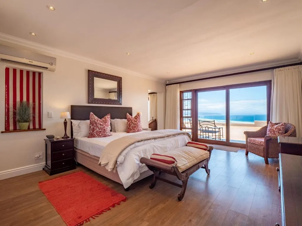 Bedroom with a wall-mounted air conditioner and sliding doors onto a sea-view balcony