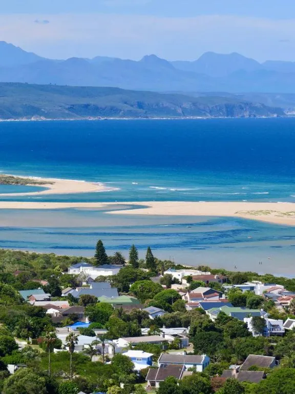 Aerial view over the Keurbooms lagoon sandbar and beach with distant mountains