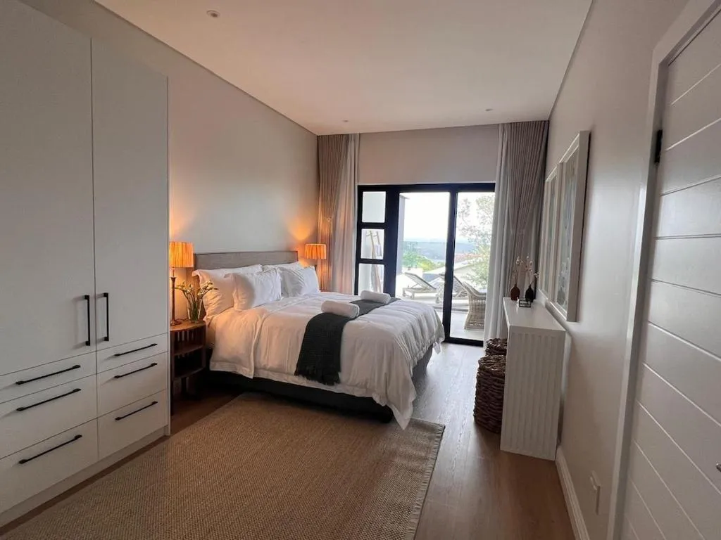 Second bedroom with a fitted wardrobe wall and glass doors leading onto a balcony with loungers