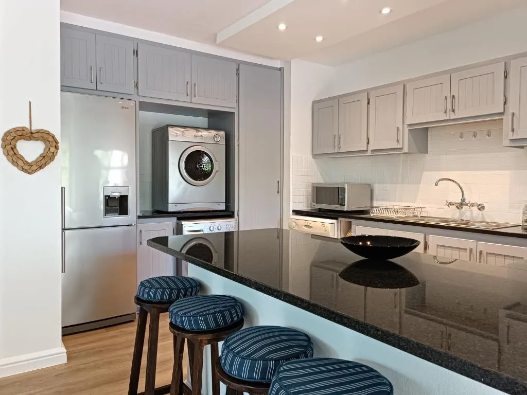 Kitchen with black granite island, gas hob, fridge-freezer and built-in washing machine