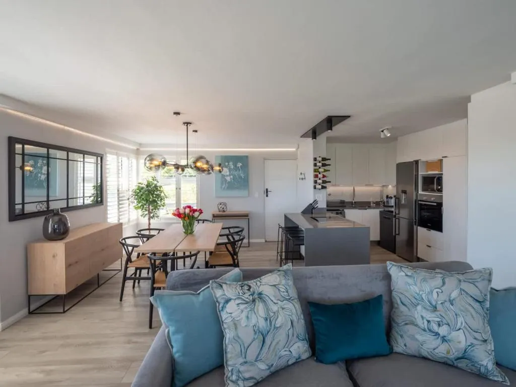 Kitchen with stainless steel appliances, a wine rack and a dining table in the foreground