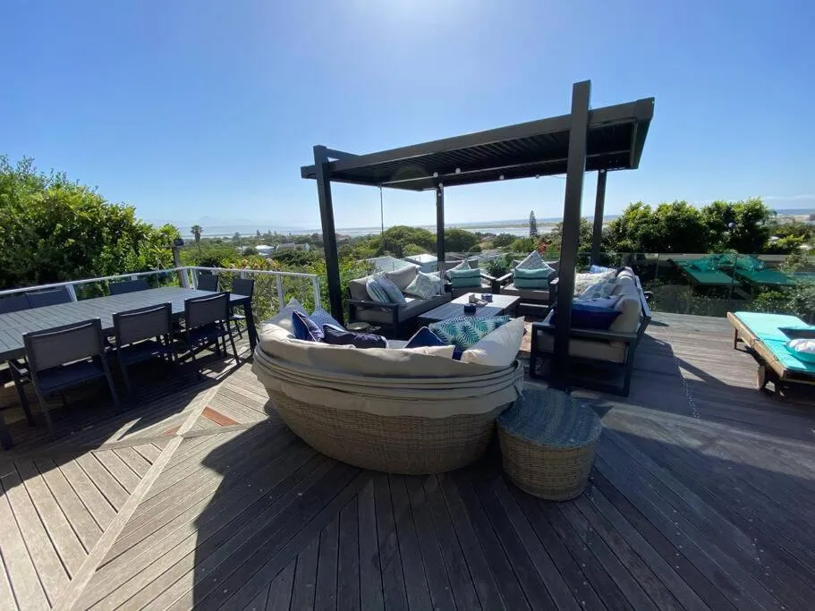 Second angle of the rooftop pergola lounge with dining table and daybed seating