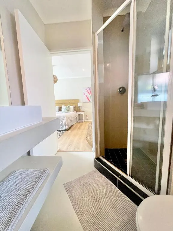 En-suite bathroom with a glass-walled shower and view through to the bedroom