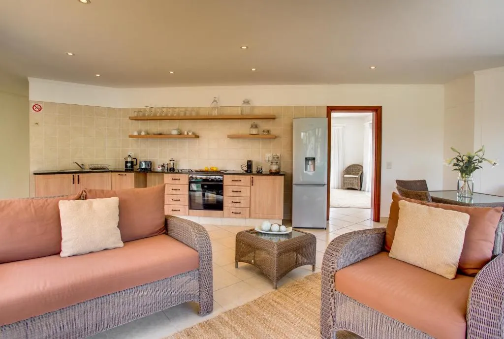 Open-plan kitchen with wicker lounge suite and coffee table in the living area