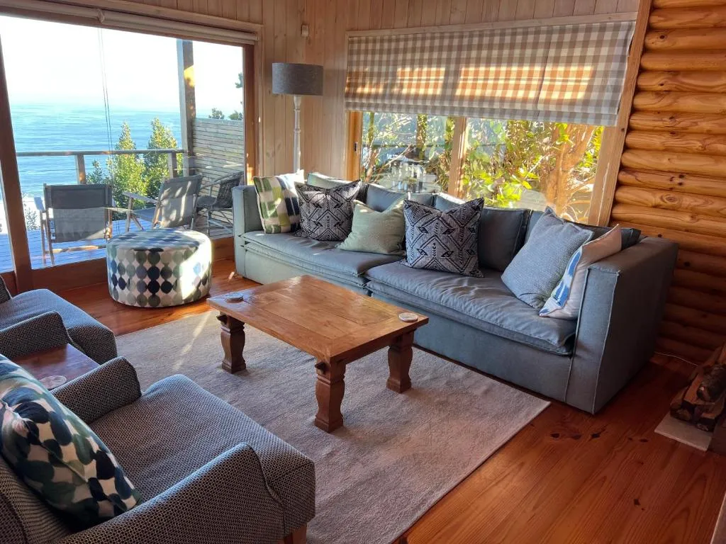 Sofa and armchairs facing a wide window with a direct view over the ocean