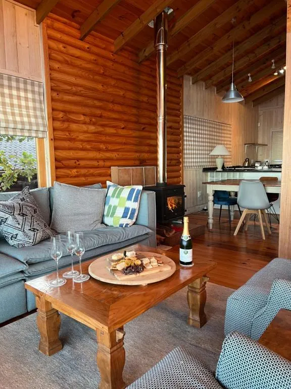 Living room with a wood-burning stove, coffee table spread and dining area beyond