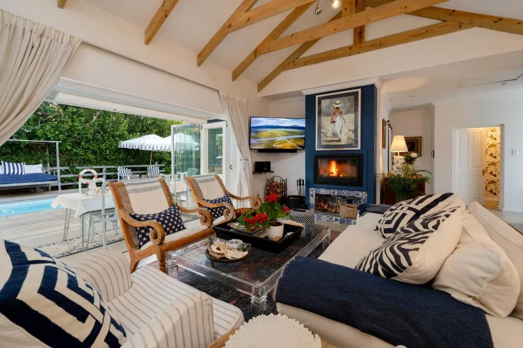 Living room with a vaulted wooden-beam ceiling, fireplace and sliding doors onto the pool deck