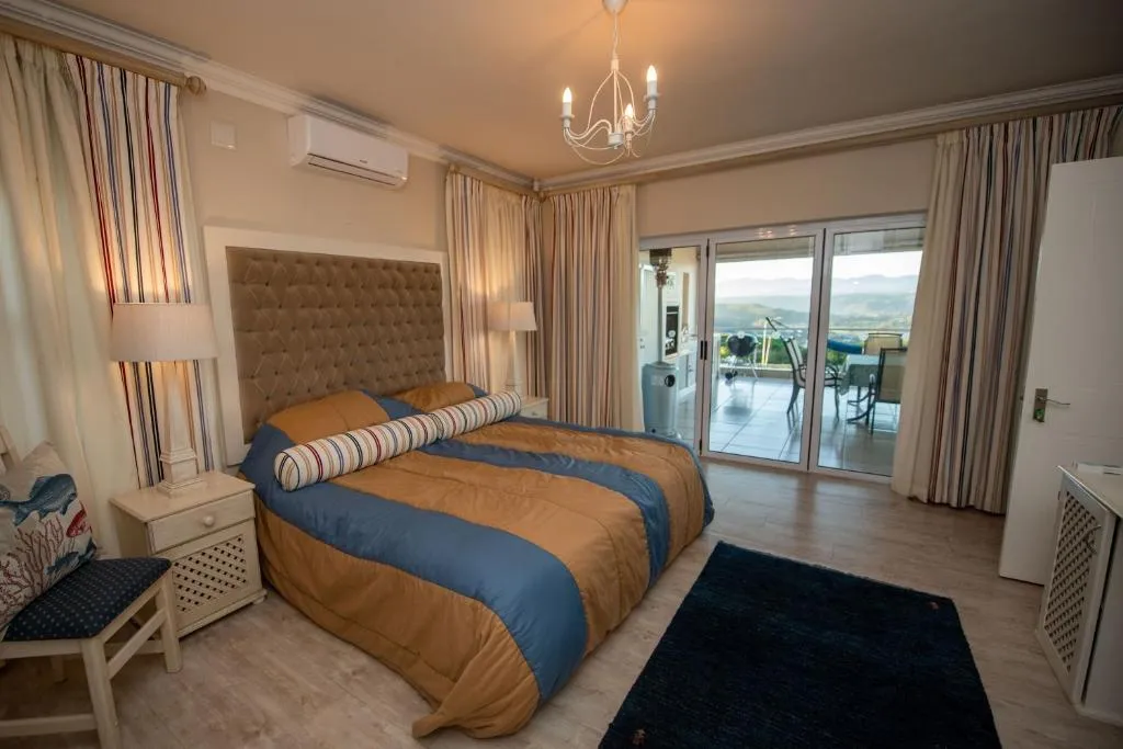 Bedroom with a king bed and sliding doors opening onto a balcony over the hills