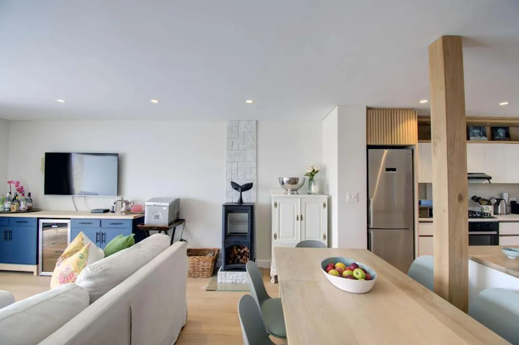 Open-plan kitchen and dining area with a wood burner and stainless steel fridge