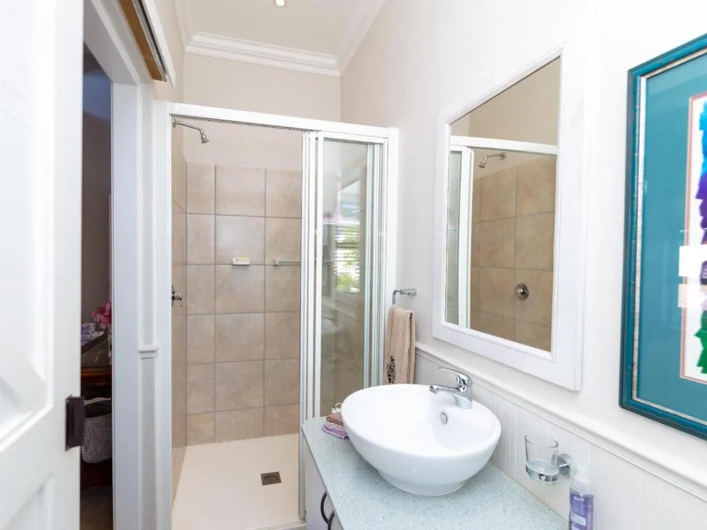 En-suite bathroom with a tiled glass shower stall and a vessel sink counter