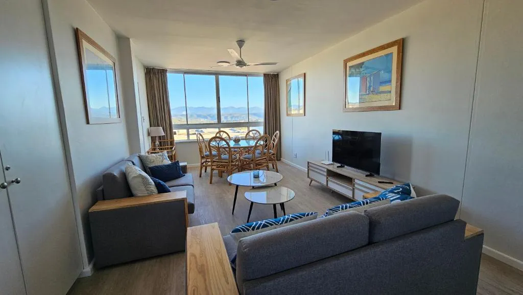 Living and dining room with a round table for six and a hazy mountain view through the window