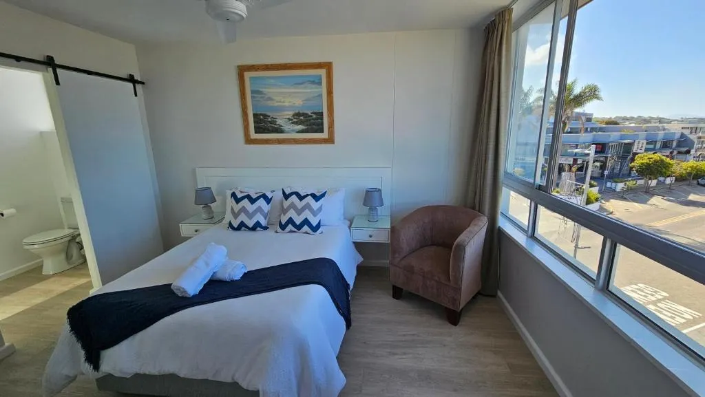 Main bedroom with a barn door opening onto the ensuite and a street-level window
