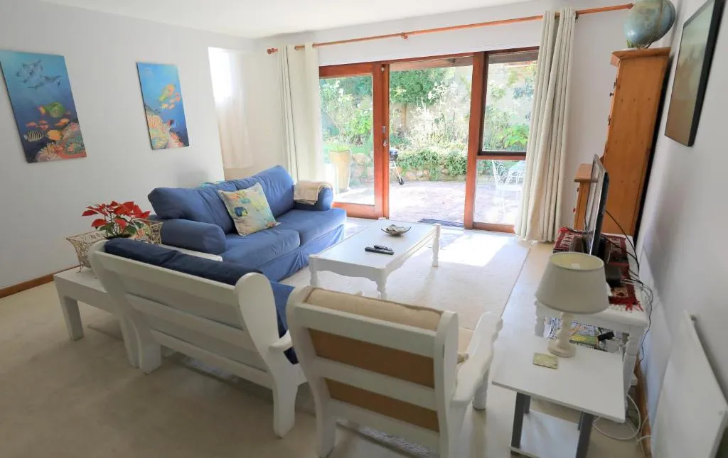 Lounge with blue sofas and sliding doors opening onto the garden patio
