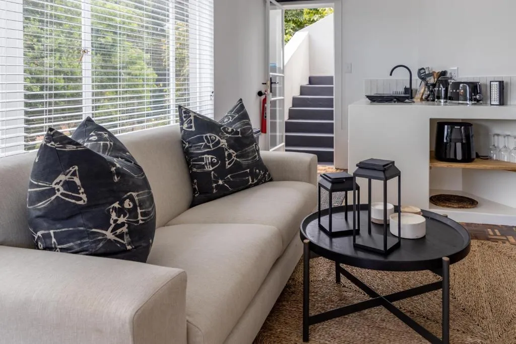 Open-plan kitchenette with lounge seating and external stairs to the entrance