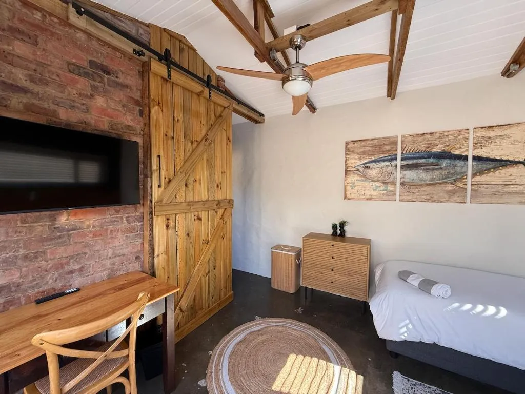 Single bedroom with a sliding barn door, wall-mounted TV and study desk