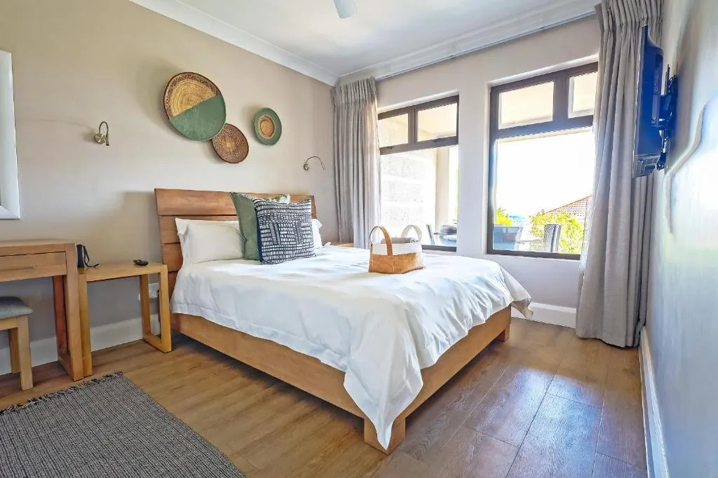 Bedroom with a wood-framed bed, woven wall baskets, and sliding doors opening onto the balcony