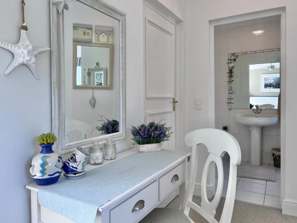 Dressing table and mirror beside an en-suite bathroom with a pedestal basin