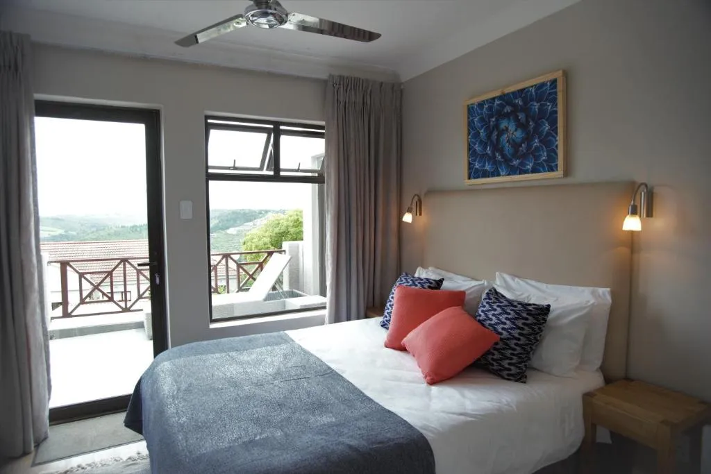 Bedroom with a balcony door opening onto a hillside valley view