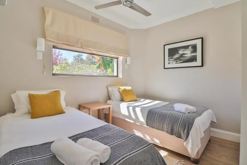 Twin bedroom with two single beds and a window looking onto greenery