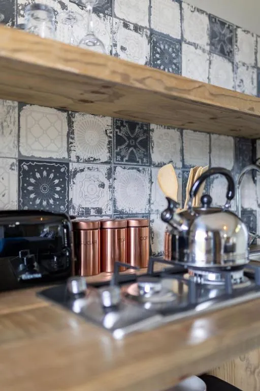 Close-up of the kitchenette with kettle, canisters and patterned tile splashback