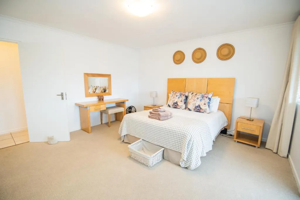 Bedroom with a dressing table, wall-mounted mirror and floral cushions