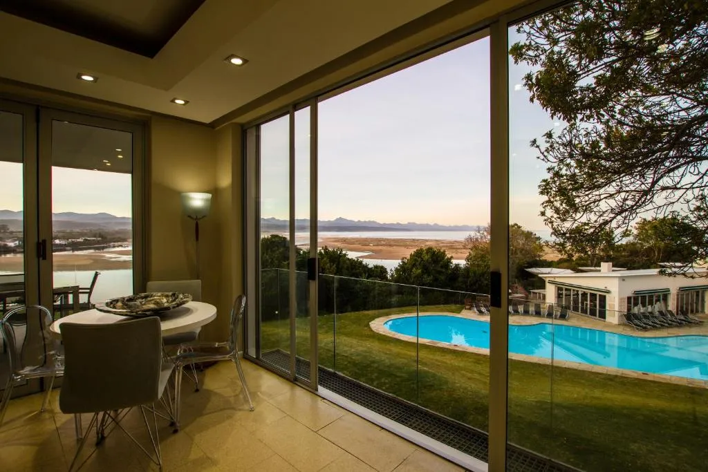 Dining table beside sliding doors overlooking the pool, lagoon and distant mountains