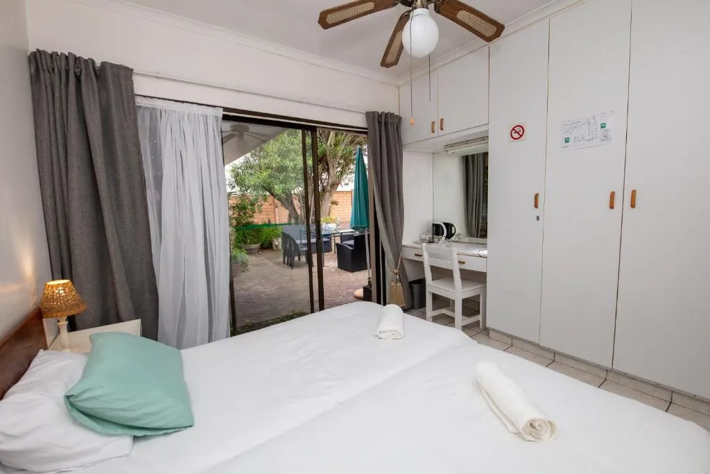 Private bedroom with sliding doors onto a small courtyard with an umbrella table