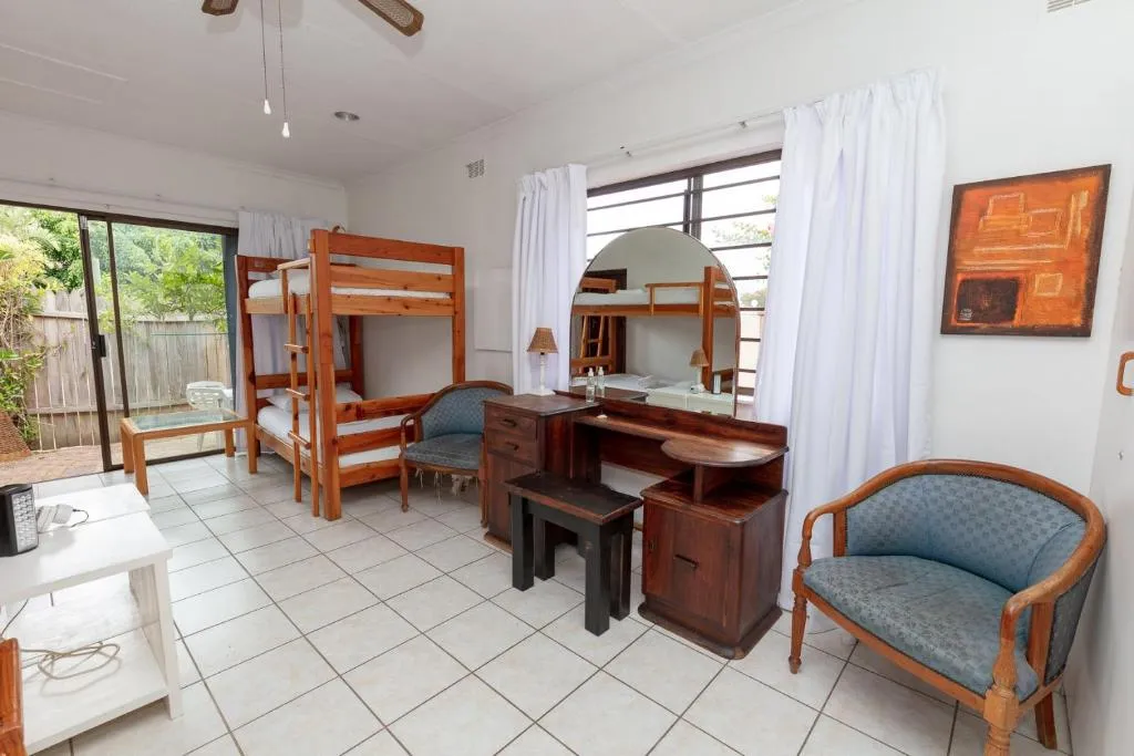 Bunk room with a wooden bunk bed and sliding doors onto a garden patio
