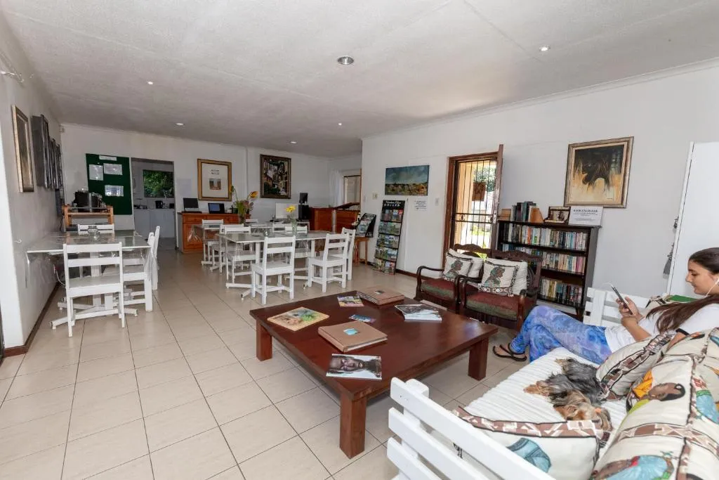 Communal lounge and dining area with a kitchenette, bookshelf and sofa