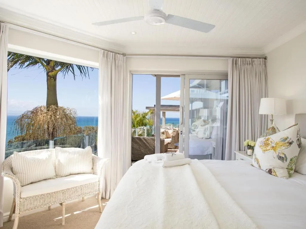 Bedroom with a sea view through a picture window and sliding doors onto the terrace