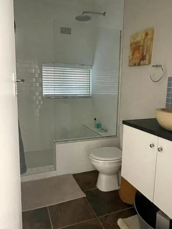 Bathroom with a glass-enclosed shower, freestanding vanity bowl and black countertop