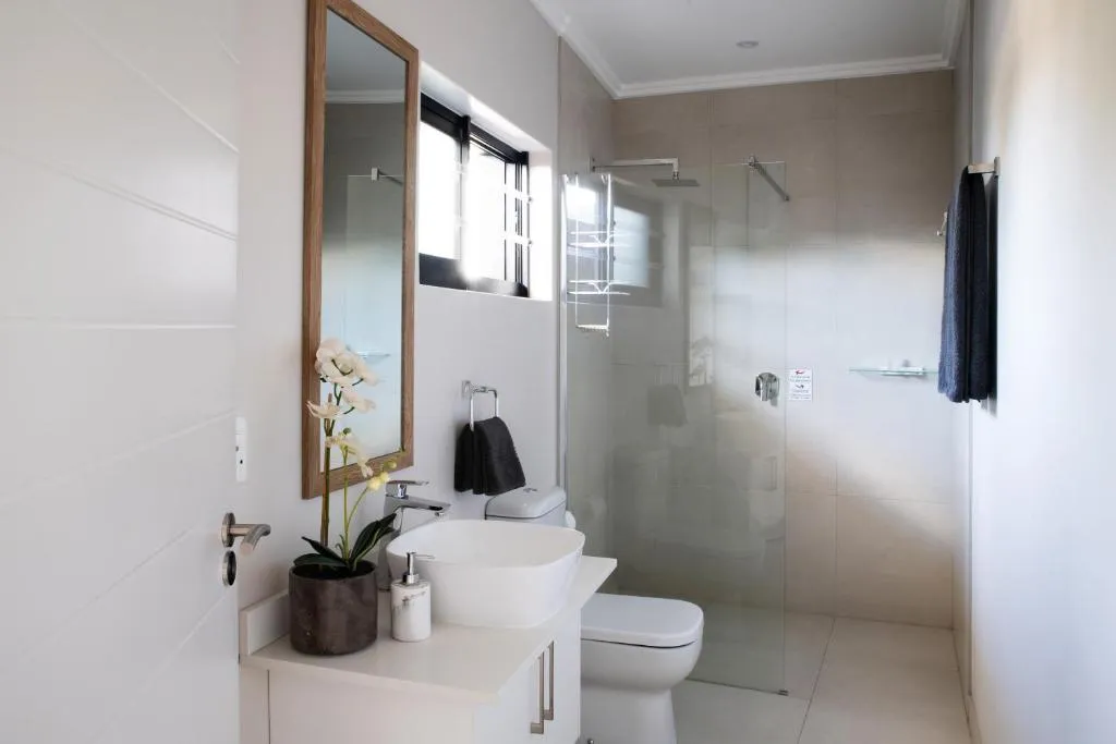 Bathroom with a vessel sink, mirror and glass-enclosed shower