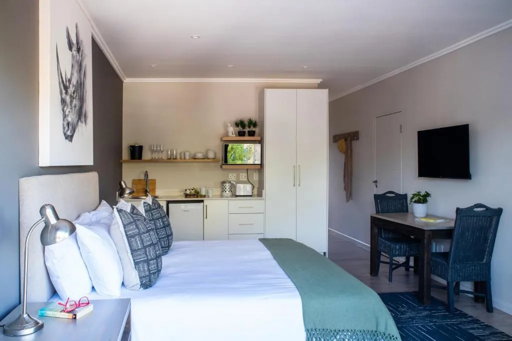 Studio apartment kitchenette with dining table, fridge and wall-mounted television