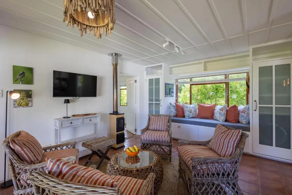 Lounge with driftwood chandelier, wood-burning stove and cushioned window seat