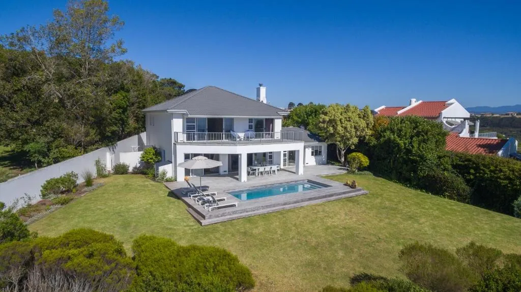 Aerial view of the house, pool deck and garden set among mature trees