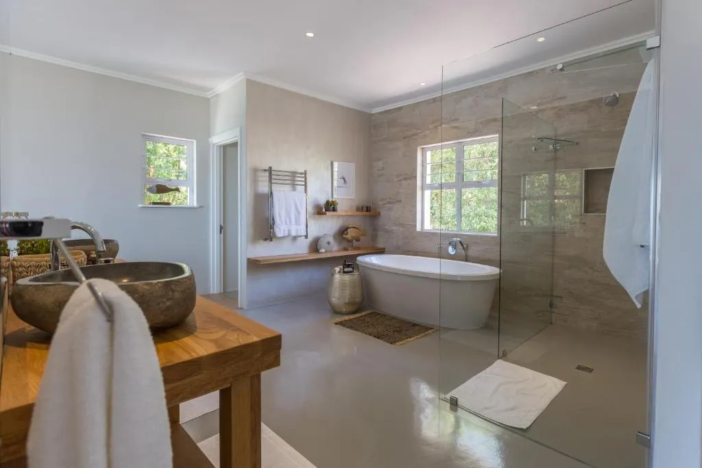 Bathroom with twin stone-vessel sinks, a freestanding tub and a glass-walled shower