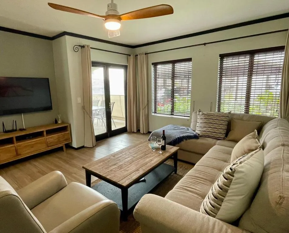 Living room with a beige corner sofa, wood coffee table and glass balcony door