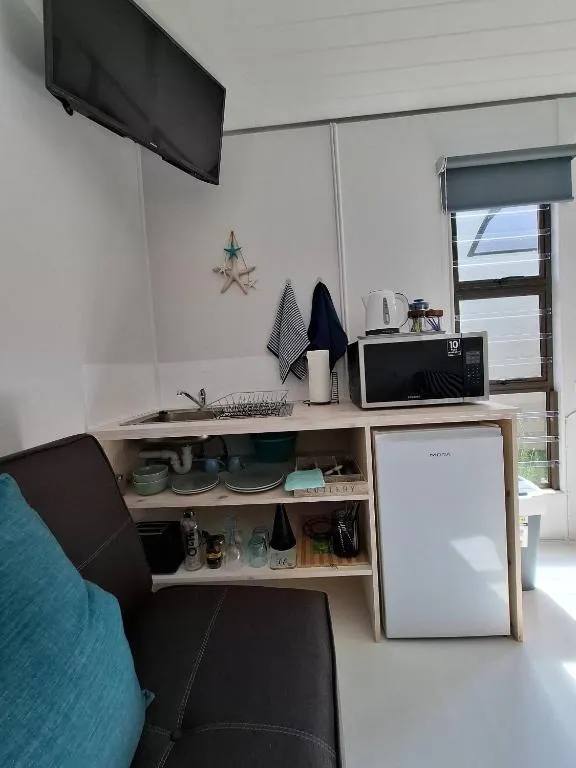Kitchenette corner with microwave, kettle, mini-fridge and wall-mounted TV