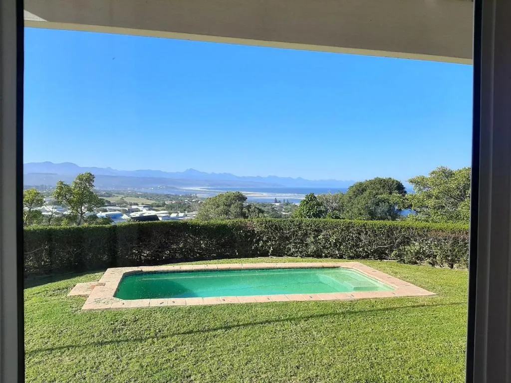 Private pool framed by hedging with the lagoon and sea visible beyond