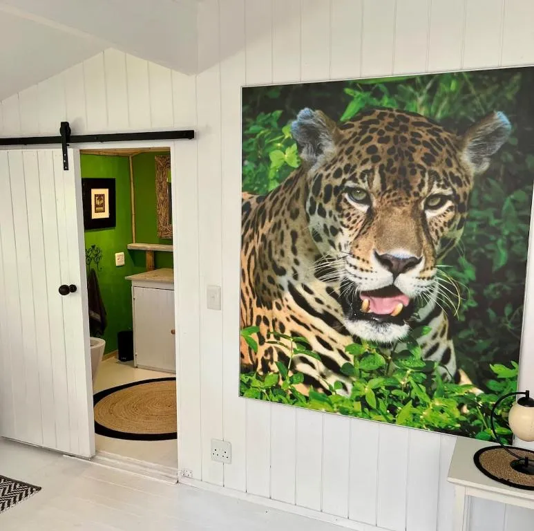 Hallway with jaguar-print wall art and a sliding door open to a bright green-walled bathroom