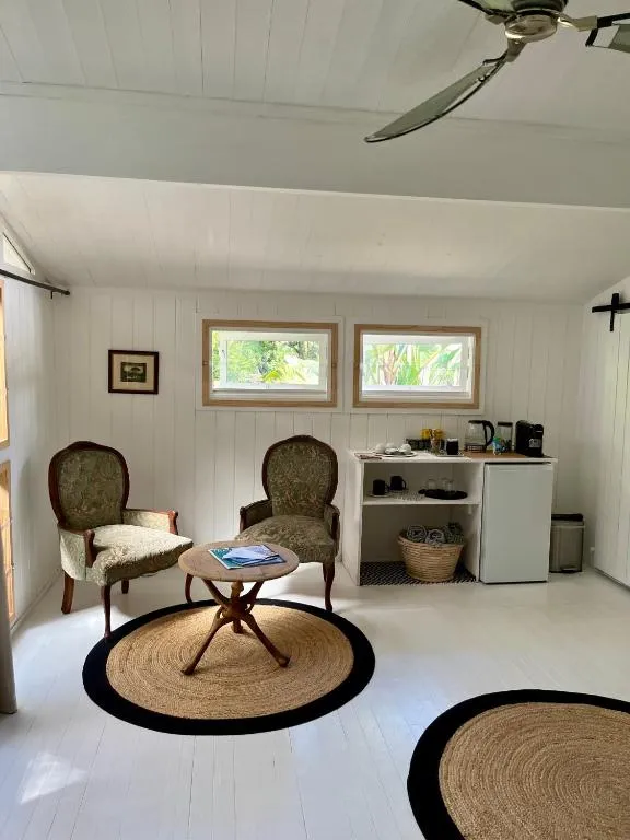 Sitting nook with two armchairs, a round table, and a small kitchenette with a mini-fridge