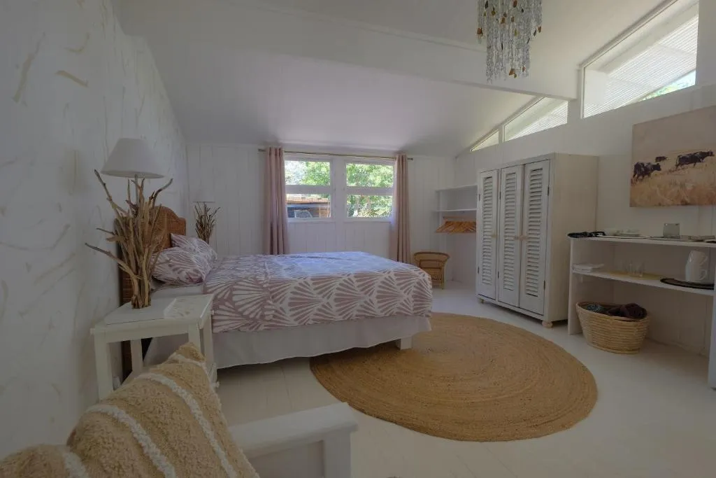 Bedroom with a shell-print bedspread, built-in wardrobe and a small tea station in the corner