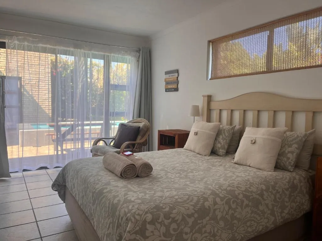 Bedroom with sliding doors opening onto the pool deck, framed by sheer curtains