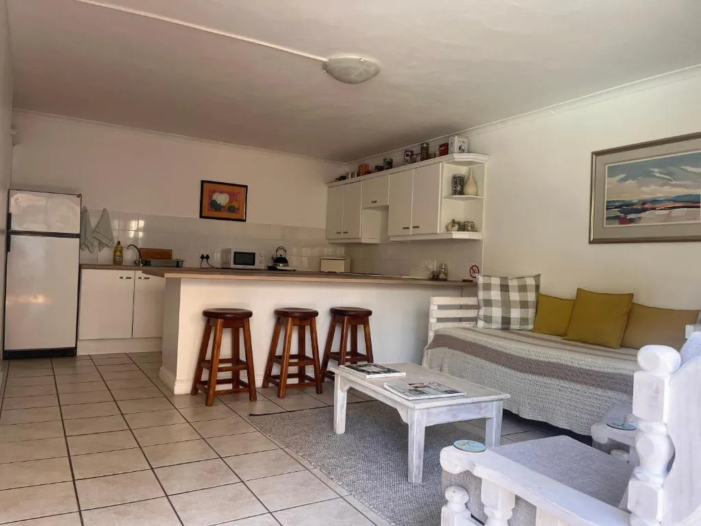 Open-plan kitchen with breakfast bar, bar stools and tiled flooring