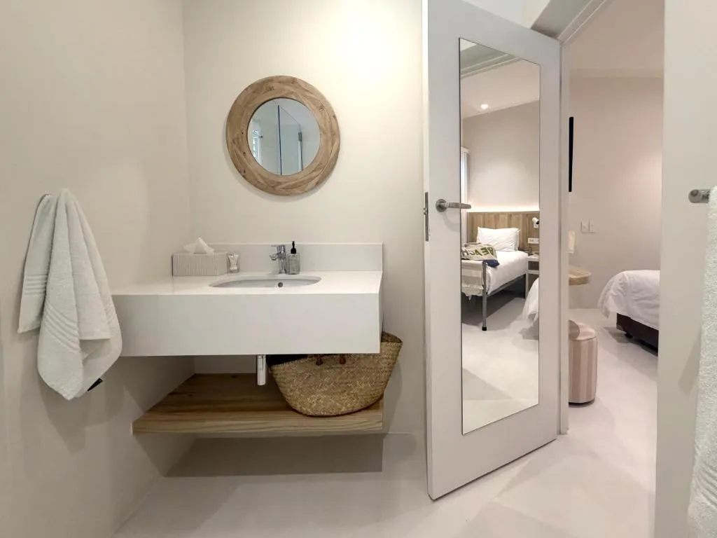 Bathroom with a floating vanity and round wood-framed mirror